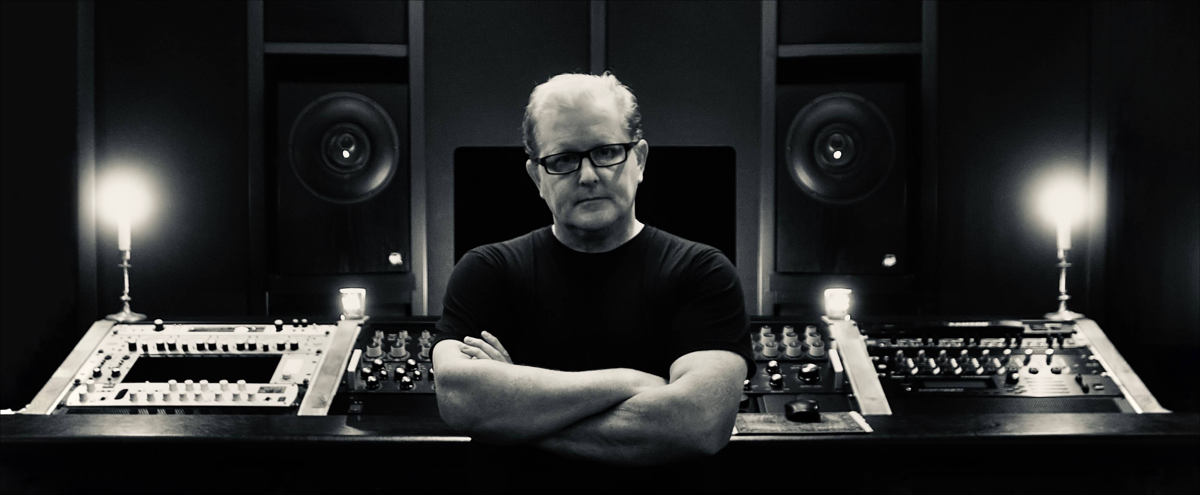 Picture of Anders Hellgren in front of his studio gear at masteringsbyrån